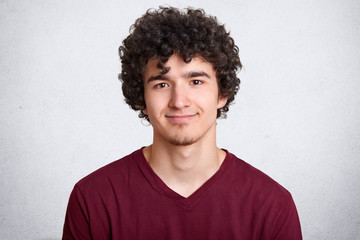 Fototapeta na wymiar Portrait of young attractive stylish fashion man, posing against white studio background, handsome happy male, has pleasant facial expressions, looking directly at camera, wearing casual shirt.