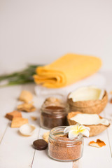 Obraz na płótnie Canvas Coconut, spa products, coffee scrub, towels and seashells on white background