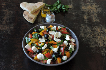 Colorful healthy salad bowl with vegetables, black olives and feta cheese.