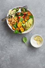 Bowl Buddha Balanced healthy vegetarian food top view Aloo gobi, tabouli salad, chickpeas, avocado, tomato and spinach