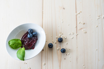 Jam from blueberries in a bowl on a wooden table. For a good delicious breakfast.