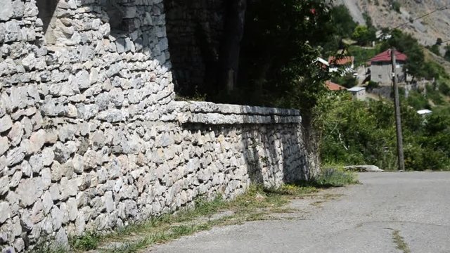 Street With A Stone Wall And An Old House with terace