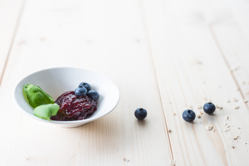 Jam from blueberries in a bowl on a wooden table. For a good delicious breakfast.