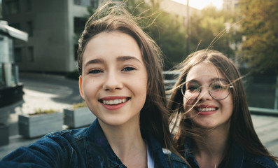 Two stylish happy girls best friends making selfie in Europe