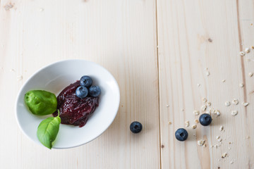 Jam from blueberries in a bowl on a wooden table. For a good delicious breakfast.