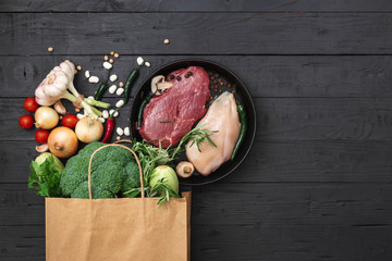 Grocery bag with healthy food on a wooden background top view