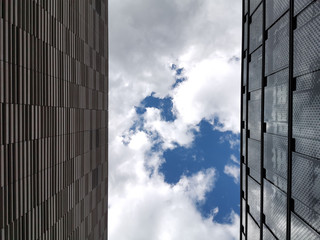sky and clouds reflected in windows of modern building