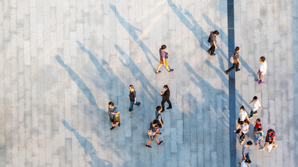 group of people walk on across the pedestrian concrete landscape in the city street (Aerial top...
