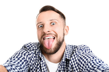 Portrait of grimacing man taking selfie on white background