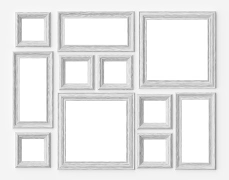 White wood photo or picture frames on white wall with shadows wi