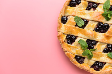 Tasty blueberry pie on color background