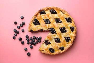 Tasty blueberry pie on color background