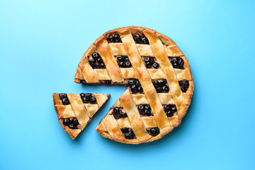 Tasty blueberry pie on color background