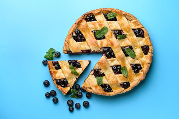 Tasty blueberry pie on color background