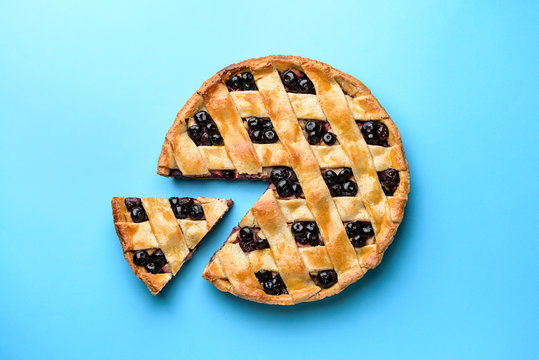 Tasty blueberry pie on color background