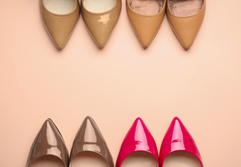 Different stylish high heeled shoes on color background