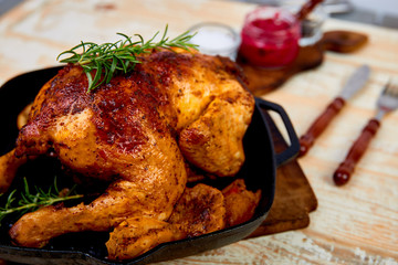 Baked whole chicken with apples in pan on wooden rustic background. Served on wooden board. Christmas chicken..