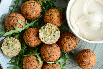 Tasty falafel balls with sauce on plate, closeup