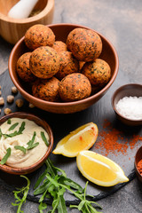 Bowl with tasty falafel balls and sauce on slate plate