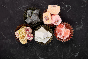 Set of various Turkish delight om black background. Top view. Flat lay.Middle Eastern dessert.