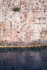 A large stone wall of beige stone in the sea