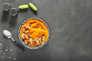 Bowl with mashed sweet potato and mushrooms on grey background