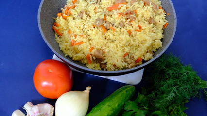 Central Asian pilaf in a cauldron with vegetables and spices