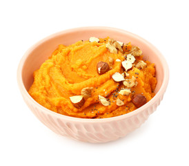 Bowl with mashed sweet potato and nuts on white background