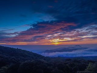 Fototapeta na wymiar sunrise at Doi Inthanon, mountain view misty morning of the hills around with sea of fog with red sun light and cloudy sky background, KM.41 local of Doi Inthanon National Park, Chiang Mai, Thailand.