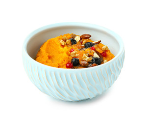 Bowl with mashed sweet potato, nuts and berries on white background