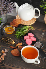glass teapot with cup of black tea on wooden table