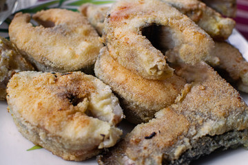 Fried fish in breading on a plate.