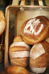 Delicious freshly baked bread at the bakery window in Barcelona, Spain. On one of the loafs there’s a city name.