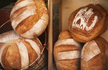 Delicious freshly baked bread at the bakery window in Barcelona, Spain. On one of the loafs there’s a city name.