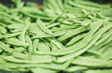 Bunch of organic grown fresh green pea pods on a supermarket shelves and busckets. Healthy eating habits. Diet ideas. Spring and summer veggies. Vegetables. Shot in Barcelona, Spain. 