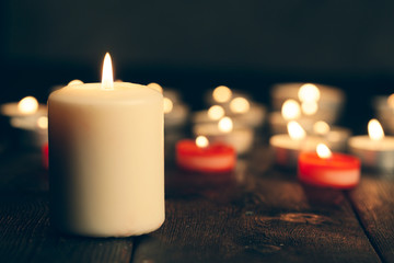 candles burning in darkness over black background. commemoration concept.
