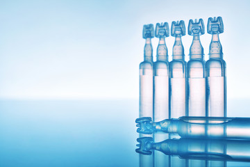 Artificial tears eye drops in plastic pipettes blue background composition