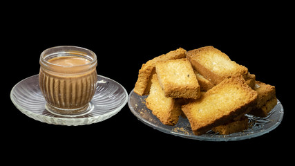 Heap of Crunchy Rusk or Toast with Cup of Tea in black background