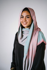Studio portrait of a beautiful, young and attractive Malay Asian woman in a traditional black dress...