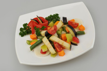 Different green vegetables on the plate gray background