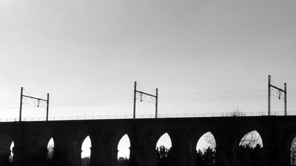 One viaduc little bridge of France in a black and white landscape. It's a train line and a water way. Black against sky