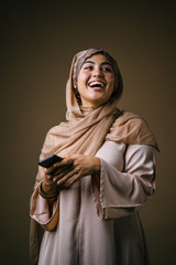 Studio portrait of a beautiful, attractive and young Middle Eastern Muslim woman in a brown...