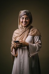Studio portrait of a beautiful, attractive and young Middle Eastern Muslim woman in a brown...