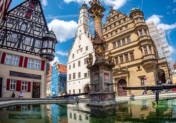 Fototapeta na wymiar Rathaus spiegelt sich im Brunnen Rothenburg ob der Tauber