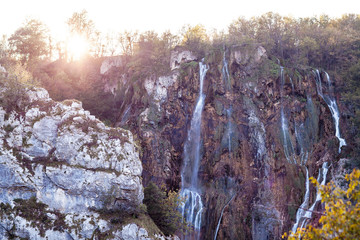 Fototapeta na wymiar Water that falls from a large waterfall over stone slopes, Plitvice Lakes