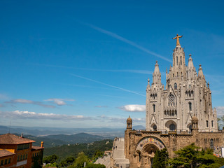 Fototapeta na wymiar Tibidabo Cathedral. Temple of the Sacred Heart of Jesus at Mount Tibidabo. Barcelona, Spain. Blue sky with cloud of spring day. Famous landmark in Catalonia.