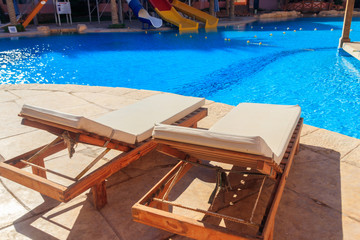 Chaise longues near a swimming pool. Concept of spa, rest, relaxation, holidays, resort