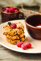 Homemade oatmeal cookies with banana, oats, nuts, eggs and flour free on grey wooden table, side view.