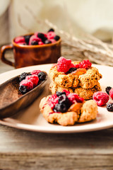 Fototapeta premium Homemade vegan crunchy oatmeal cookies with raspberry jam and date caramel on a grey wooden background.