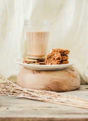 Flourless gluten free peanut butter, oatmeal and date with a glass of milk on a wooden background. Copy space.